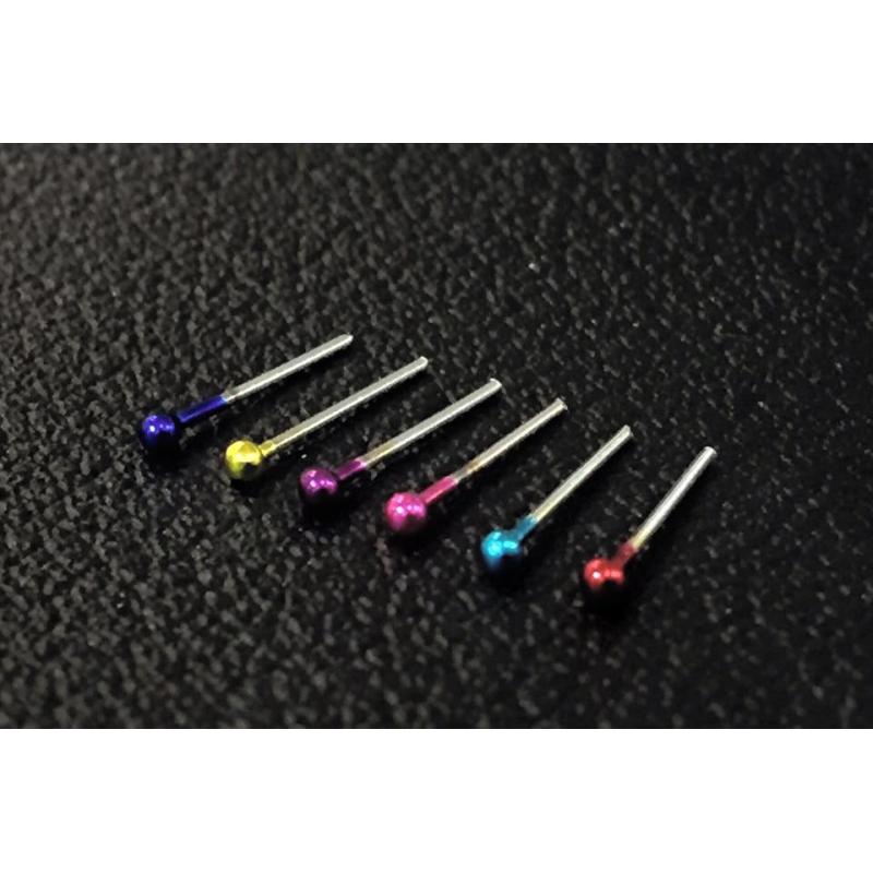 Surgical steel nose piercing with colored dots.